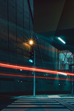 Red light streaks across a street intersection at night